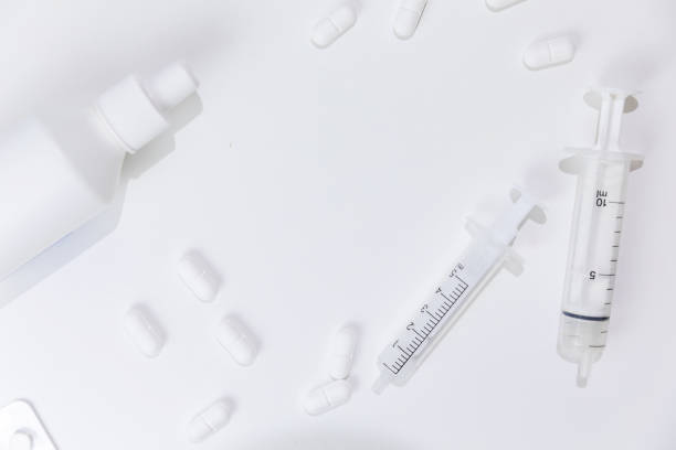 istock Medical syringe and pills isolated on white background 1215483487