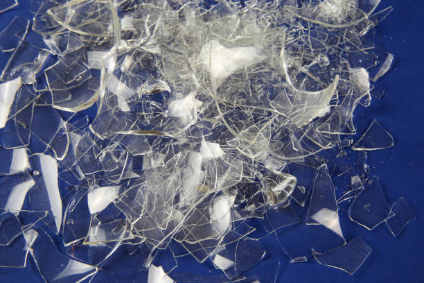istock Shattered into 1000 shards concept: View on isolated pile broken glass fragments, blue background 1215485546