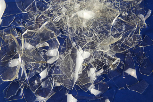 istock Shattered into 1000 shards concept: View on isolated pile broken glass fragments, blue background 1215485554
