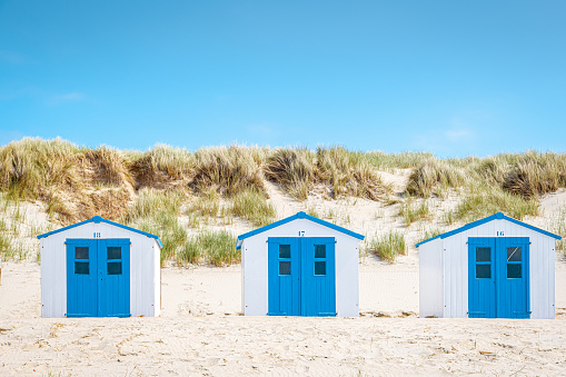 Texel Island Netherlands, blue white cabin on the beach hut on the beach with on the background the sand dunes of Texel Holland during summer