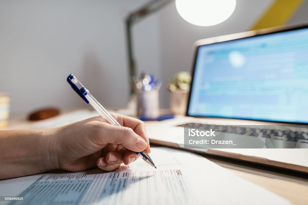 Deadline for submission of tax forms is July 15 instead of April 15 due to pandemic Coronavirus Working from home due to social distancing , woman is filling out tax form Tax Form Stock Photo