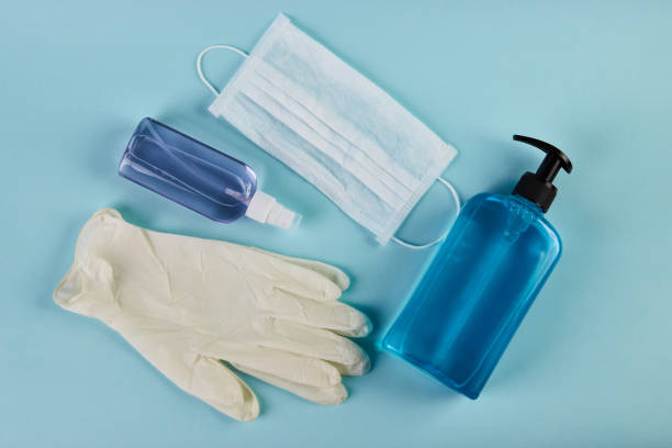 маска для лица с бутылкой дезинфицирующего средства для рук, дозатором жидкого мыла и латексными перчатками - protective glove washing up glove cleaning latex стоковые фото и изображения