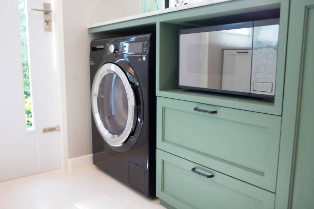 istock Corner counter with washing machine and microwave in kitchen. 1215494844