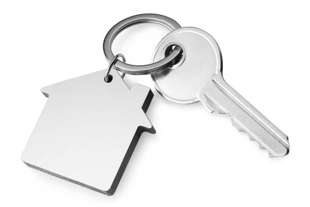 ключ от дома с брелоком в форме дома на белом - door nobody macro close up стоковые фото и изображения