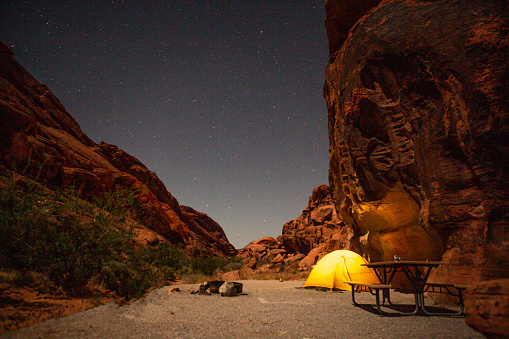 Night shot of Yellow tent pinched in red sandstone campsite in Valley of fire state park in Nevada USA