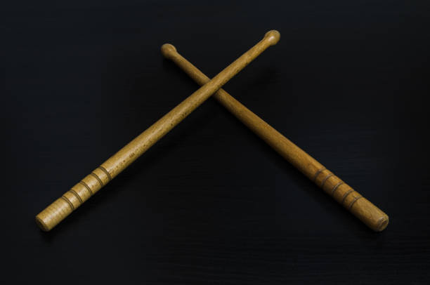 CROSSED WOOD DRUMSTICKS ON BLACK BACKGROUND