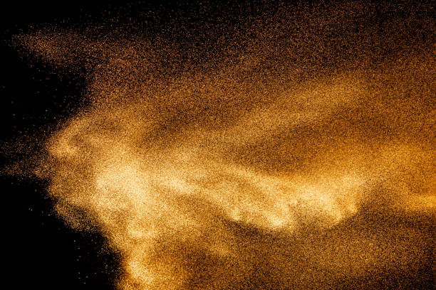 istock Golden sand explosion isolated on black background. Abstract sand cloud.Sandy fly wave in the air. 1215500568