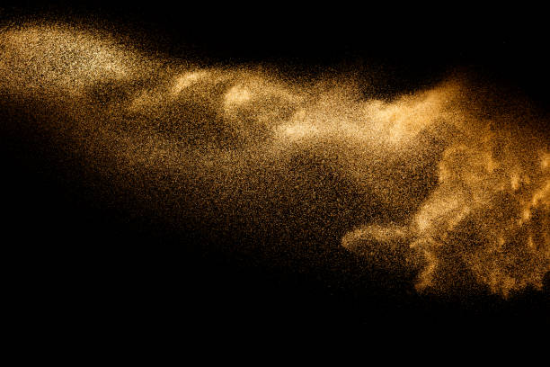 istock Golden sand explosion isolated on black background. Abstract sand cloud.Sandy fly wave in the air. 1215500581