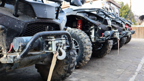 muitos atvs estacionados em uma estrada de terra, de perto. carro de quatro rodas, veículo todo-terreno. rodas grandes com pernas poderosas. passeio de montanha nos cárpatos - motor scooter vacations motor vehicle usa - fotografias e filmes do acervo