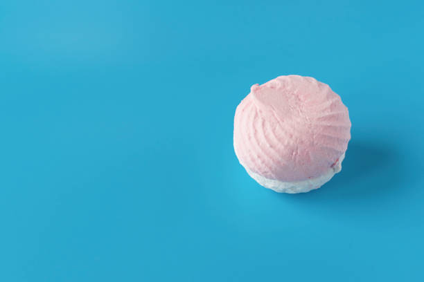istock Pink and white sweet air marshmallows on a blue background. Delicate dessert 1215503494