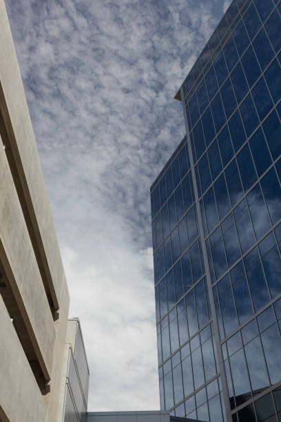 istock Contemporary architecture, space between parking garage and modern glass building reflecting blue sky 1215503596
