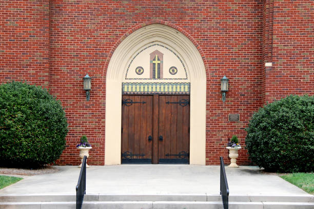istock ornate oak church doors brick walls hedges 1215503881
