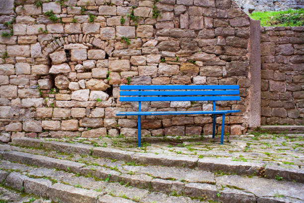 istock Blue bench next to the stones wall in labin 1215505106