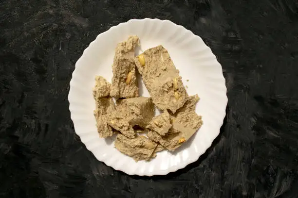 Photo of Sunflower seed halva in white plate on gray rustic background