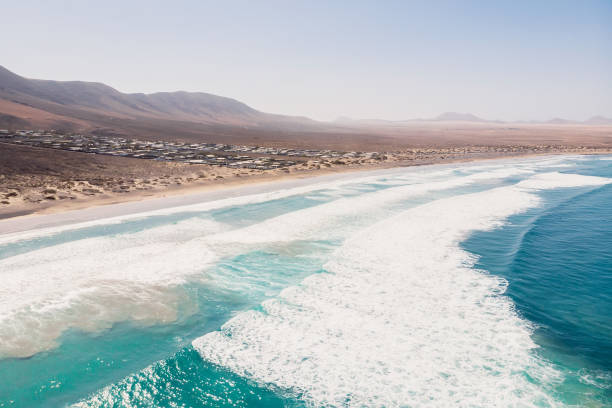 Aerial view of Famara beach, scenic landscape with blue ocean and mountains in Lanzarote, Canary islands Aerial view of Famara beach, scenic landscape with blue ocean and mountains in Lanzarote, Canary islands caleta de famara lanzarote stock pictures, royalty-free photos & images