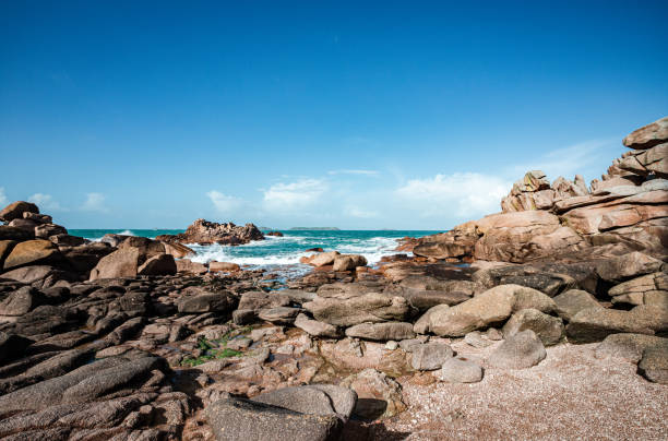 Pink granite coast on the Breton coast west of Perros-Guirec\nThe photo was taken at the Ploumanac'h lighthouse\nThe weather is variable and the sun highlights the color of granite\nThe tide is rising\nWe are at the lighthouse of Men Ruz on a small beach