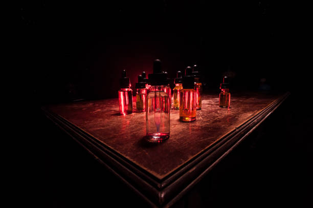 istock Smoke clouds and vape liquid bottles on dark background. Light effects. Useful as background or vape advertisement or vape background. Selective focus 1215510909