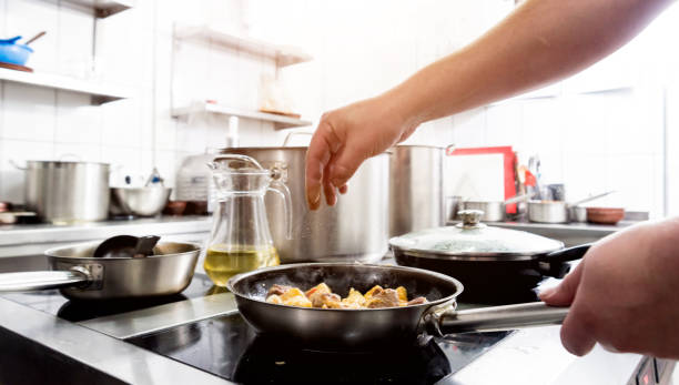 istock Chef cooks fried potatoes with pieces of meat in a restaurant kitchen 1215511147