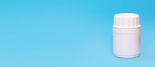 istock White medical bottle vial on a blue background.Copy space for text.Banner 1215511469