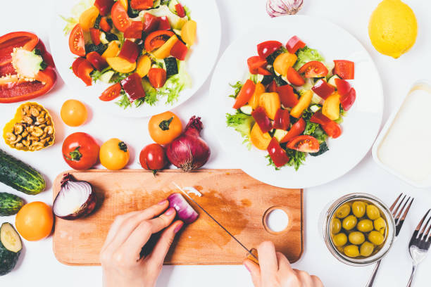 istock Top view of female hands chop onion on a cutting board 1215512897