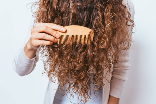 istock Young woman brushing her curly hair 1215512952