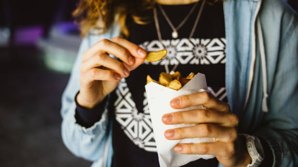 istock Closeup unrecognizable young woman eating fast food 1215512966