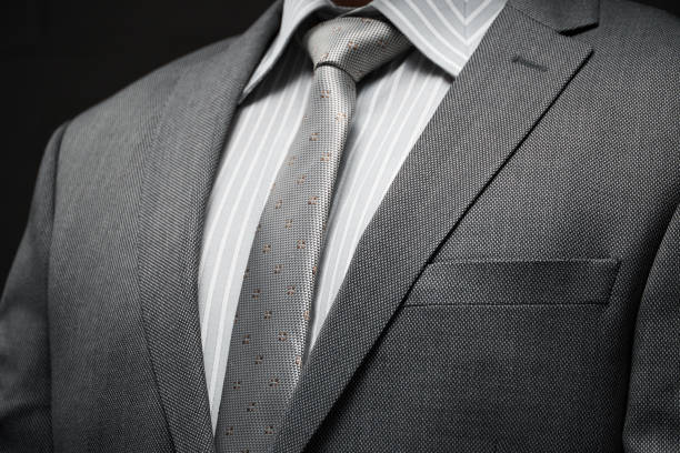 istock businessman portrait dressed in gray suit, dark wall background 1215515903