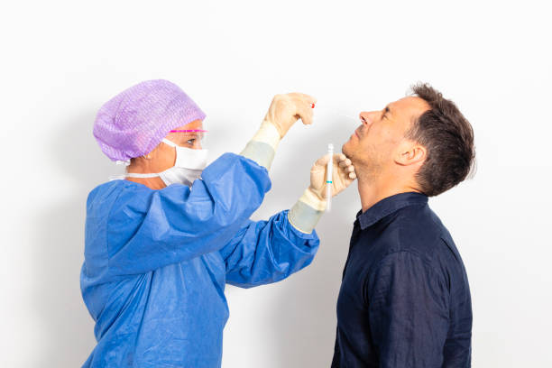 A doctor taking a nasal swab A doctor in a protective suit taking a nasal swab from a person to test for possible coronavirus infection 3610 stock pictures, royalty-free photos & images