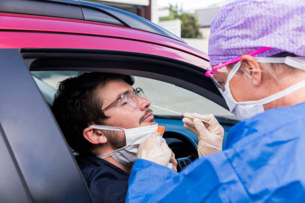 istock A doctor taking a nasal swab from a driver 1215518843