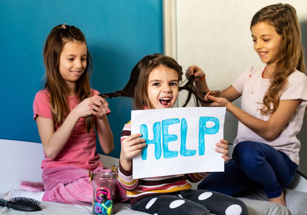 istock Small girl need help while sisters braided her hair 1215519077