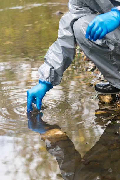 istock lab worker in protective suit takes water from a river for further analysis 1215521294