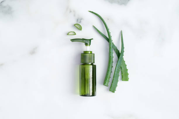 Aloe vera cosmetic bottle and plant leaves on marble desk. Natural organic beauty product, skin care concept. Flat lay, top view. Aloe vera cosmetic bottle and plant leaves on marble desk. Natural organic beauty product, skin care concept. Flat lay, top view. aloe plant alternative medicine body care stock pictures, royalty-free photos & images