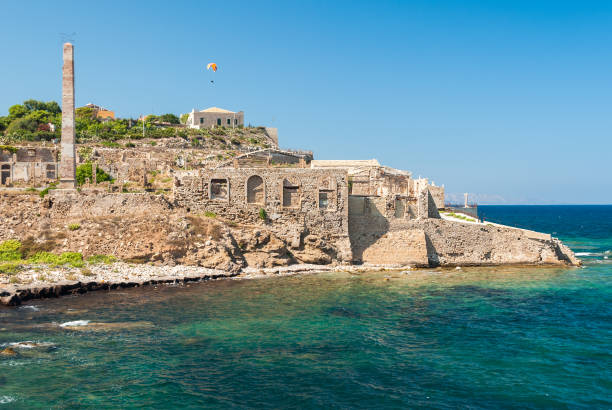 Coastline of Portopalo, in southern Sicily, with the ruins of an old factory Coastline of Portopalo, in southern Sicily, with the ruins of an old factory. portopalo stock pictures, royalty-free photos & images