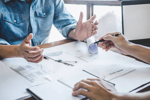istock Construction and structure concept of engineer working drawing on blueprint meeting for project working with partner on model building and engineering tools in working site, construction concept 1215522941