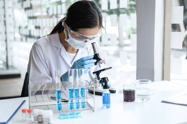 istock Scientist or medical in lab coat working in biotechnological laboratory, Microscope equipment for research with mixing reagents in glass flask in clinical laboratory 1215522969