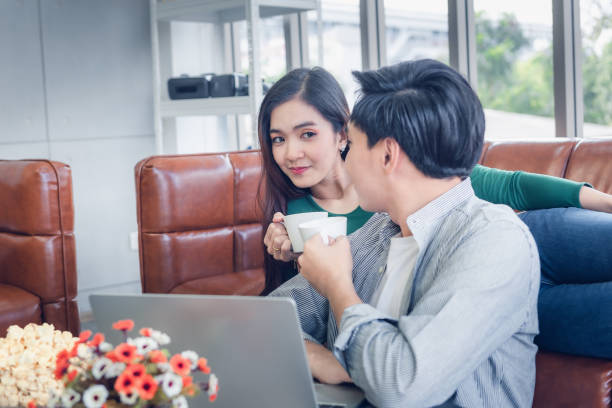 istock Couple Love Having Relaxation Discussing While Drinking a Coffee in Their Home, Attractive Asian Couple Happiness in Romantic Moments at Living Room. Relaxing and Lifestyles Concept 1215524394