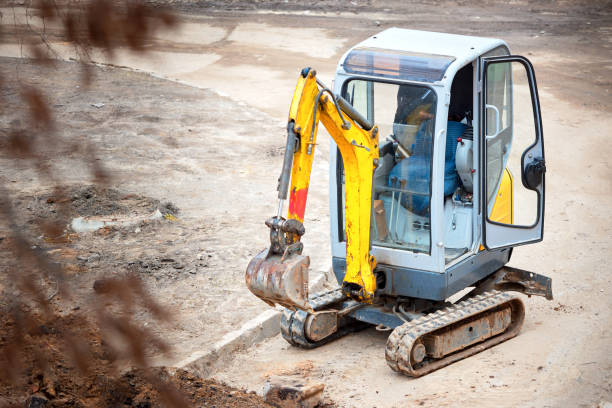 istock Tracked mini excavator breaks out old curbs before installing new curbs. The concept of using economical and compact equipment 1215526933