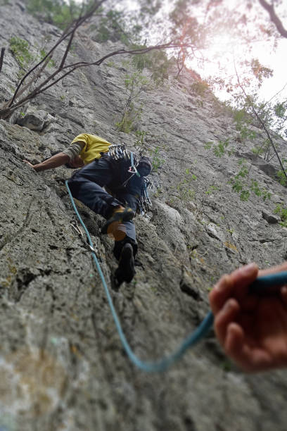 istock Young man is climbing in Potrero de Chico in Mexico and man secure him with rope 1215528529