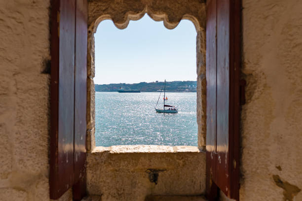 Small boat seen through an old window of an ancient fort stock photo