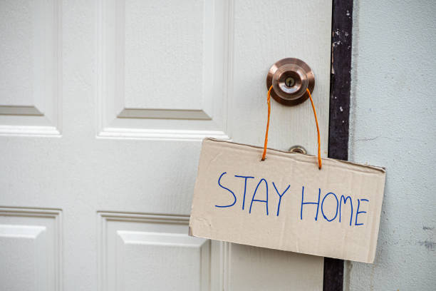 istock STAY HOME cardboard sign hanging on door. 1215529221