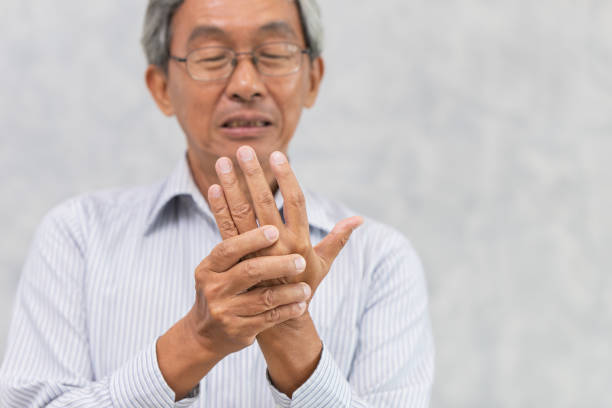 elder hand pain with trigger finger or rheumatoid arthritis. - finger on the trigger imagens e fotografias de stock