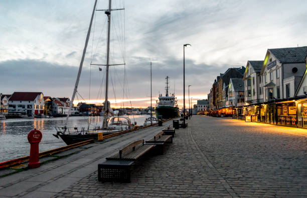 Walking promenade in the evening at Haugesund city center and harbor with restaurants, cafes and recreational boats parked stock photo