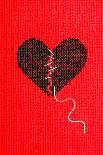 istock Black broken heart on red background. Embroidery. 1215530610