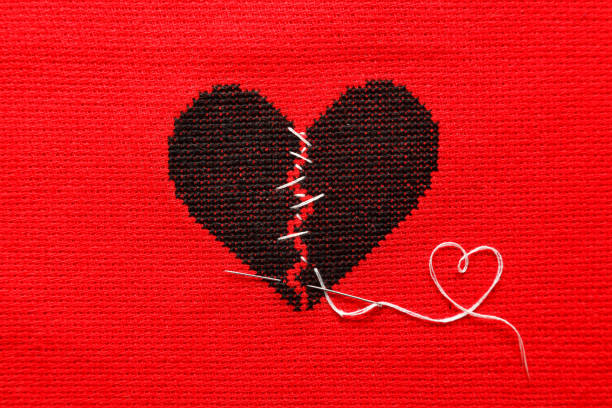 istock Black broken heart on red background. Embroidery. 1215530662