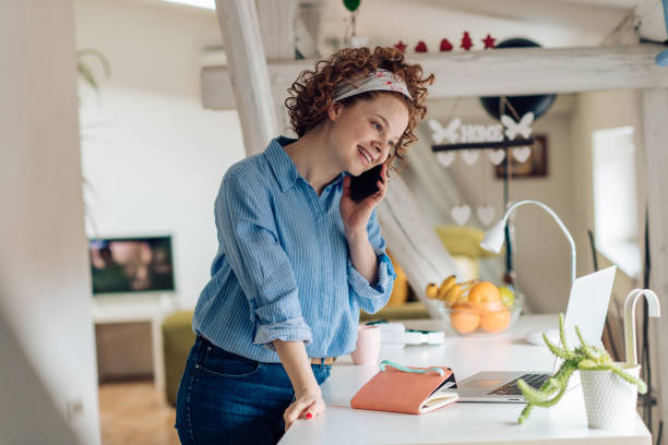istock Young woman having a business call while working from home 1215533339