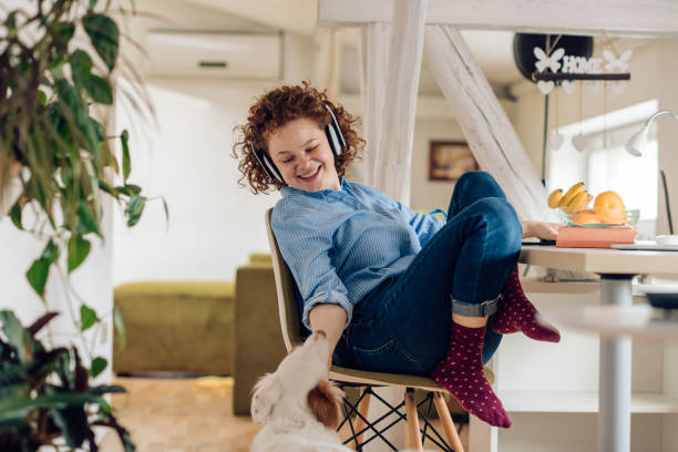 istock Young woman cuddling her dog while working from home 1215533343