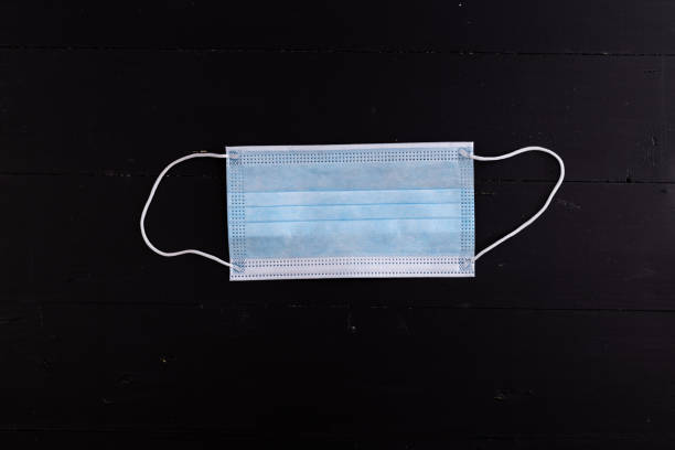 istock Surgical and virus protective blue masks above black background with copy space 1215534007