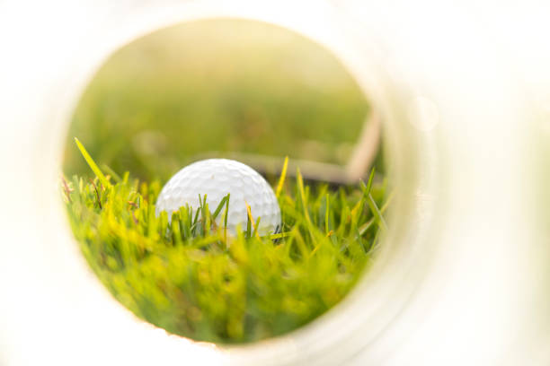 istock golf ball and club on green grass - view from the hole 1215535006