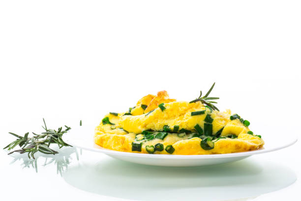 hot fried omelet with chopped green onions in a plate isolated on white background