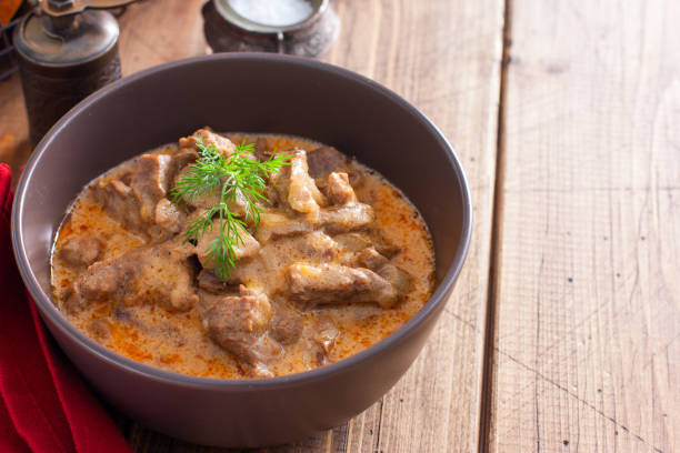 istock Traditional beef stroganoff in ceramic bowl on a wooden table, horizontal, copy space 1215537509